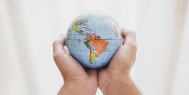 a-person-s-hand-holding-small-globe.jpg